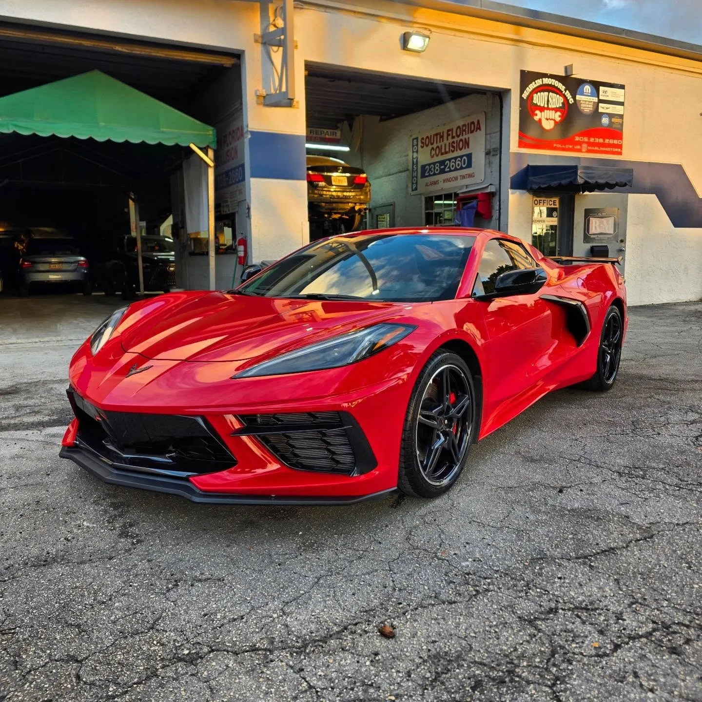 Red Corvette after collision repair in front of the Marlin Motors body shop in Cutler Bay, FL